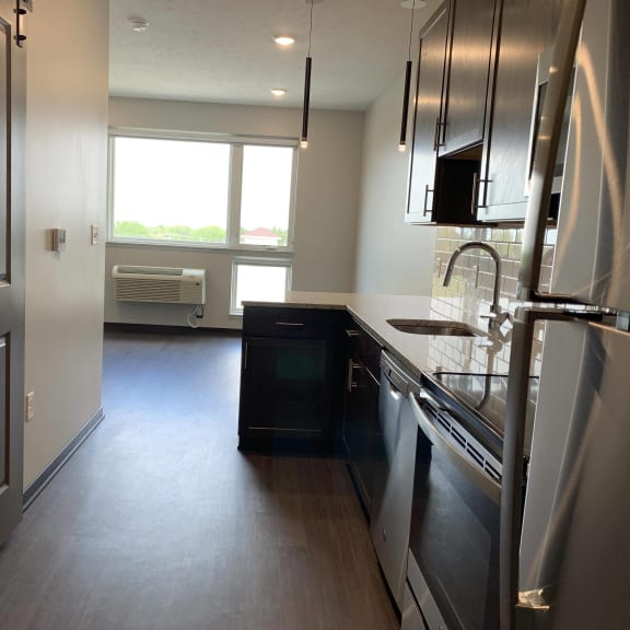Thumbnail 4 of 12 Kitchen leading into dining area in studio at luxury apartment in Lincoln