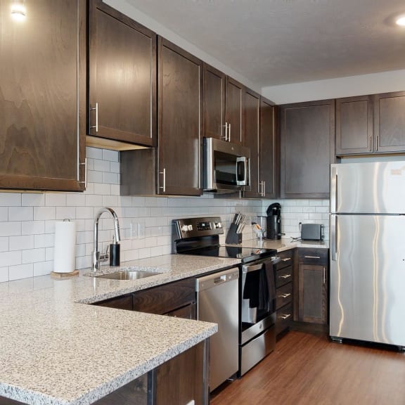 Thumbnail 2 of 23 a kitchen with dark wood cabinets and white granite countertops