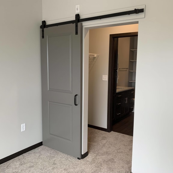 Thumbnail 10 of 15 Open barn door looking into a pass through walk in closet in a one bedroom apartment in Lincoln
