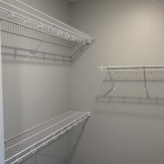 Thumbnail 12 of 15 Large empty walk in closet with upper and lower wire racks for clothing storage