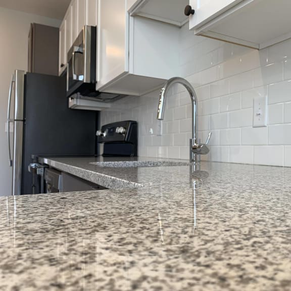 Thumbnail 3 of 11 Close up of light granite counters and white subway tile backsplash