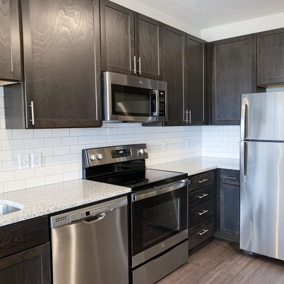Thumbnail 13 of 23 corner of kitchen with stainless steel appliances and warm brown cabinets for storage