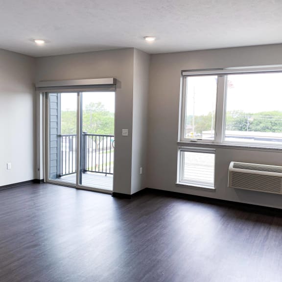 Thumbnail 18 of 23 Living and sleeping area with bright windows and a sliding patio door