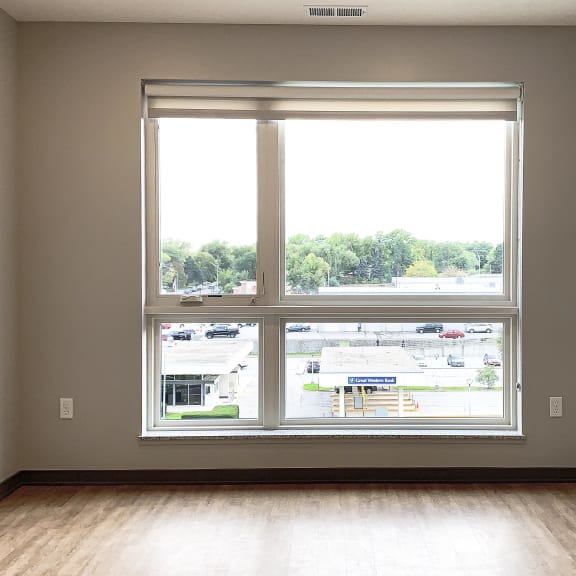 Thumbnail 6 of 8 bedroom with hardwood floors and a large floor to ceiling window