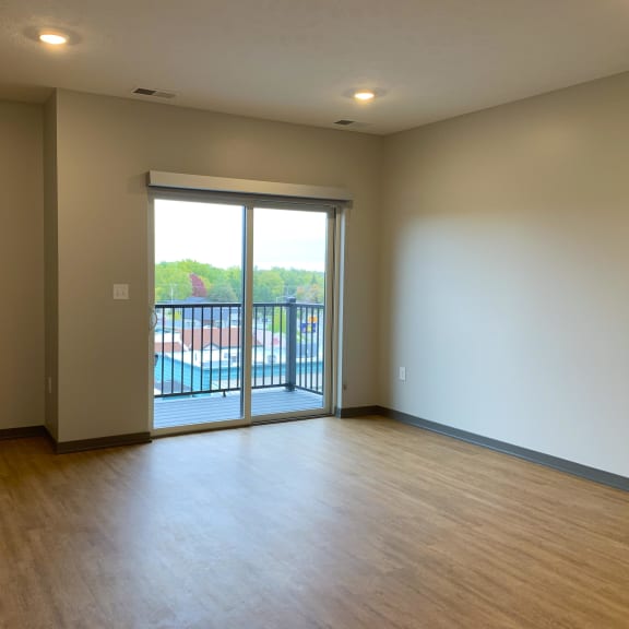 Thumbnail 7 of 13 Open living room open dining room with sliding glass door to balcony at Haven at Uptown in Lincoln, Nebraska