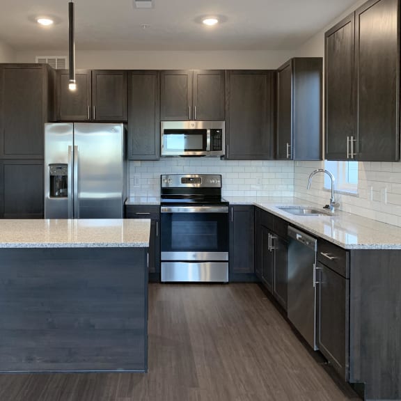 Thumbnail 4 of 18 Kitchen with dark brown cabinets and large kitchen island and matching stainless steel  appliances