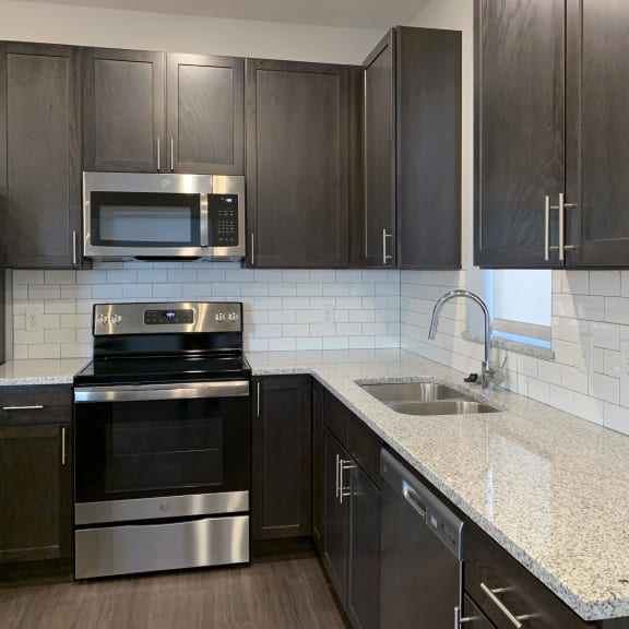 Thumbnail 2 of 18 Kitchen with dark brown cabinets and large kitchen island and matching stainless steel  appliances