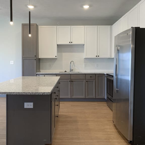 Thumbnail 4 of 16 Kitchen with white upper cabinets and gray lower cabinets at Haven at Uptown