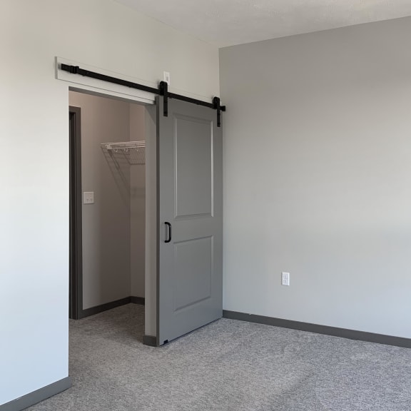 Thumbnail 10 of 16 Master bedroom with barn doors leading to closet and bathroom at Haven at Uptown
