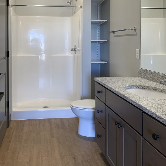 Thumbnail 14 of 16 Large bathroom with standing shower and storage shelves at Haven at Uptown