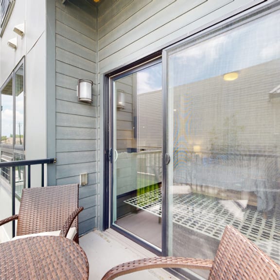 Thumbnail 10 of 23 a balcony with a table and chairs and a sliding glass door