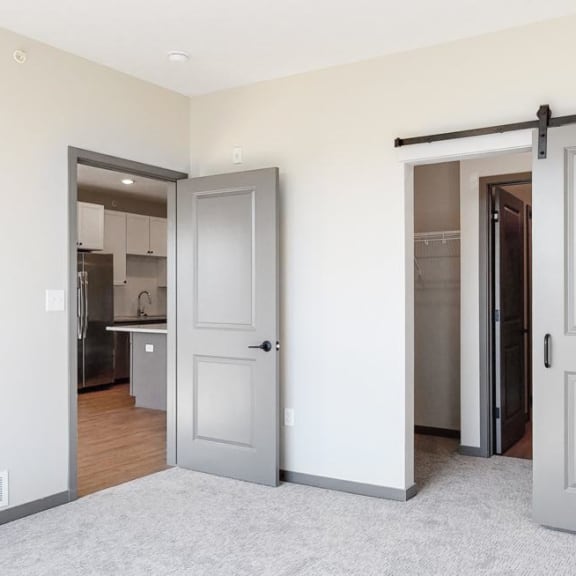 Thumbnail 17 of 19 Sliding barn doors leading to closet space and the bathroom from the bedroom in the Bliss floor plan at Haven at Uptown in Lincoln, NE