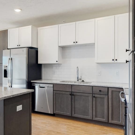 Thumbnail 13 of 19 Beautiful kitchen completed with two tone slate finishes, including pendant lighting and stainless steel appliances in the Bliss floor plan at Haven at Uptown in Lincoln, NE
