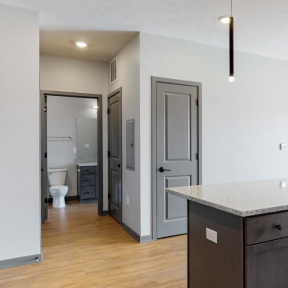 Thumbnail 16 of 19 View of kitchen island and hallway leading to the bathroom in the Bliss floor plan at Haven at Uptown in Lincoln, NE