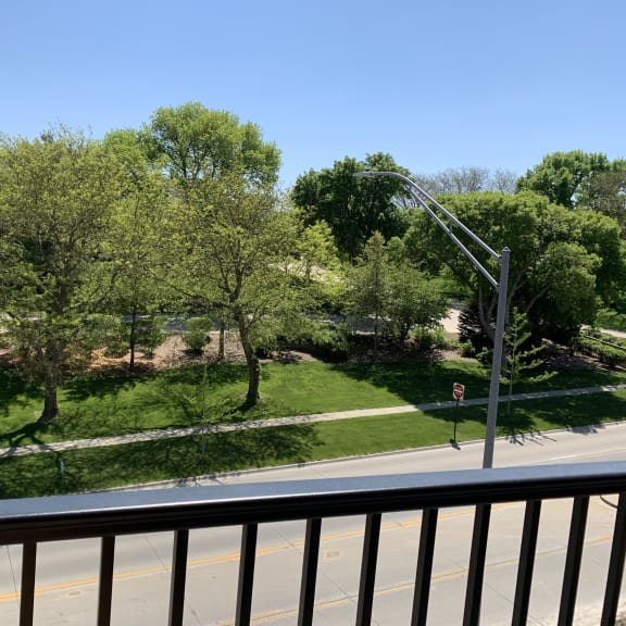 Thumbnail 6 of 19 Scenic tree filled park view from outdoor balcony at Haven at Uptown in Lincoln.