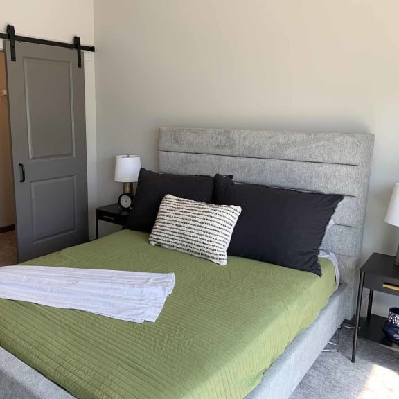 Thumbnail 7 of 19 a bedroom with a bed and a closet with sliding barn door