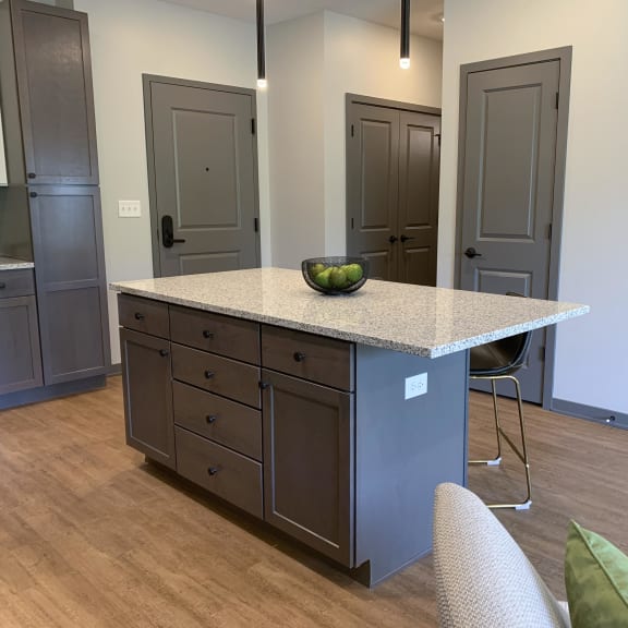 Thumbnail 11 of 19 Large kitchen island with abundant storage and bar stools and pendant lights in the Bliss floor plan at Haven at Uptown in Lincoln.