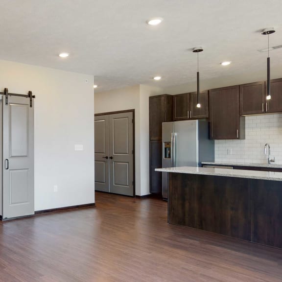 Thumbnail 6 of 17 Living space with sliding barn doors leading to an office space in the Melody floor plan at Haven at Uptown in Lincoln, NE