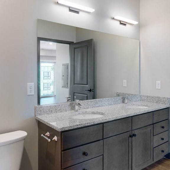 Thumbnail 15 of 17 Dual sinks and light granite counter tops, as well is slate grey cabinetry for extra storage in the bathroom at Haven at Uptown in Linooln, NE