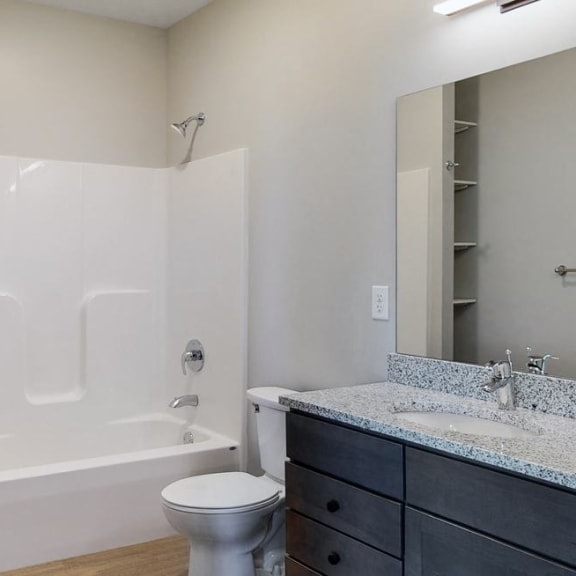 Thumbnail 16 of 17 Bathroom with dual sink counter tops, a bathtub, and shelves for additional storage at Haven at Uptown in Lincoln, NE