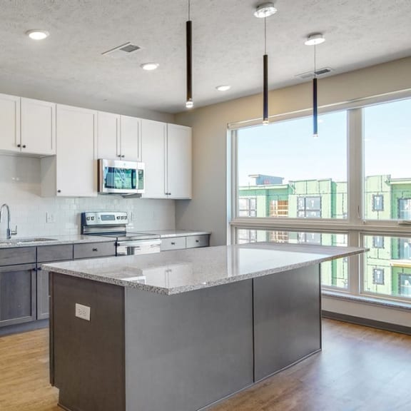 Thumbnail 9 of 17 Large windows filter abundant natural light into the spacious kitchen in the Melody floor plan at Haven at Uptown in Lincoln, NE
