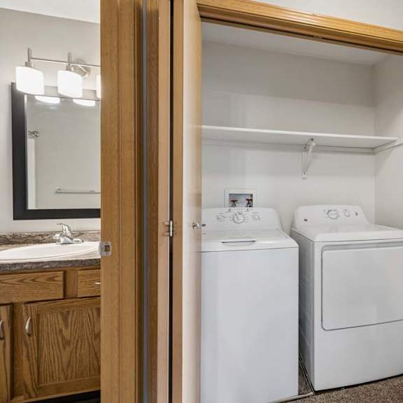Thumbnail 21 of 21 Laundry closet with full-size washer and dryer, overhead shelving, and convenient placement beside the bathroom and bedroom.