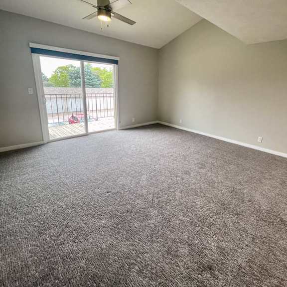 Thumbnail 10 of 12 a living room with a ceiling fan and carpeted floor