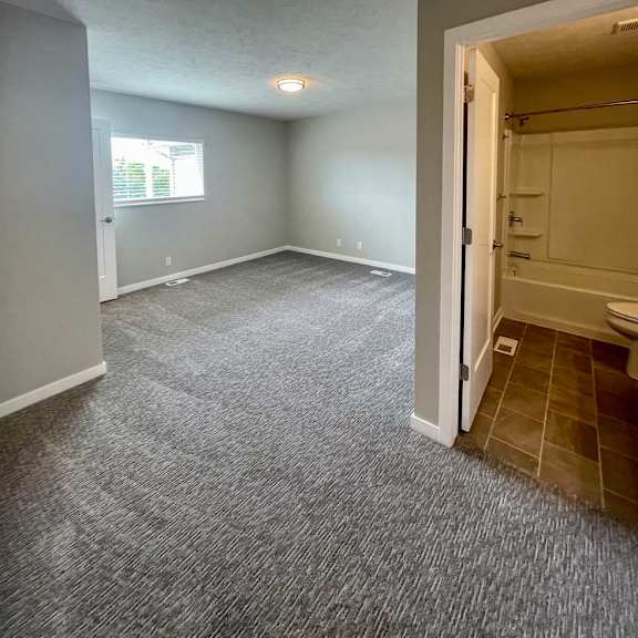 Thumbnail 12 of 12 a bedroom with a carpeted floor and an attached bathroom