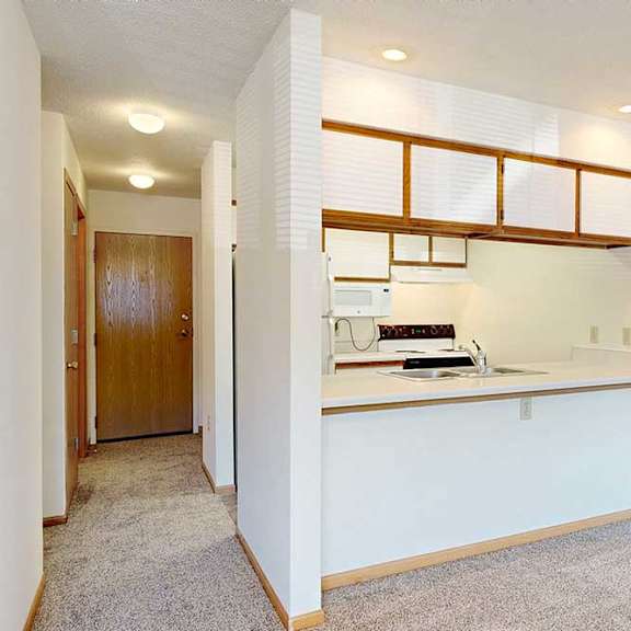 Thumbnail 13 of 29 A galley kitchen layout with white range, a passthrough window, and wood trim cabinetry