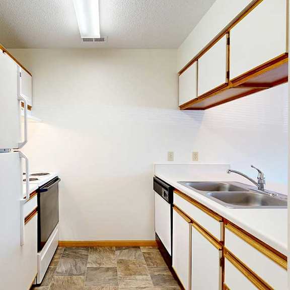 Thumbnail 3 of 29 A kitchen with white appliances, white and wooden cabinetry, and dual sink