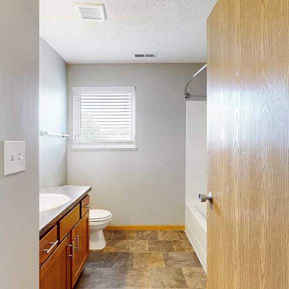 Thumbnail 23 of 28 A bathroom with a toilet, sink, and window.