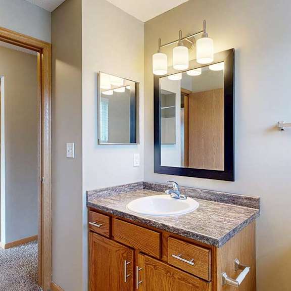 Thumbnail 24 of 28 a bathroom with a vanity sink, mirror, medicine cabinet, overhead lighting, and a towel bar