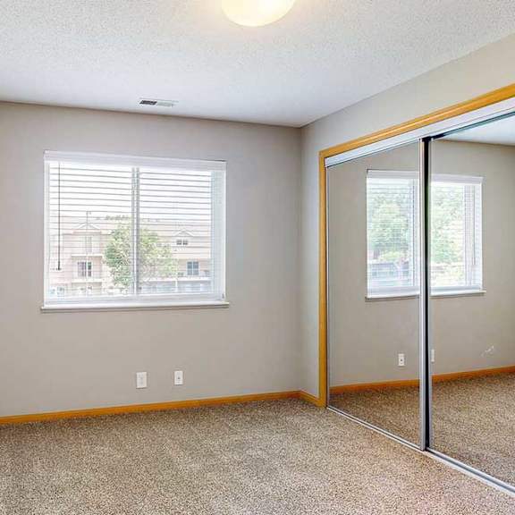 Thumbnail 27 of 28 a bedroom with carpet, large window, and closet with sliding mirror doors