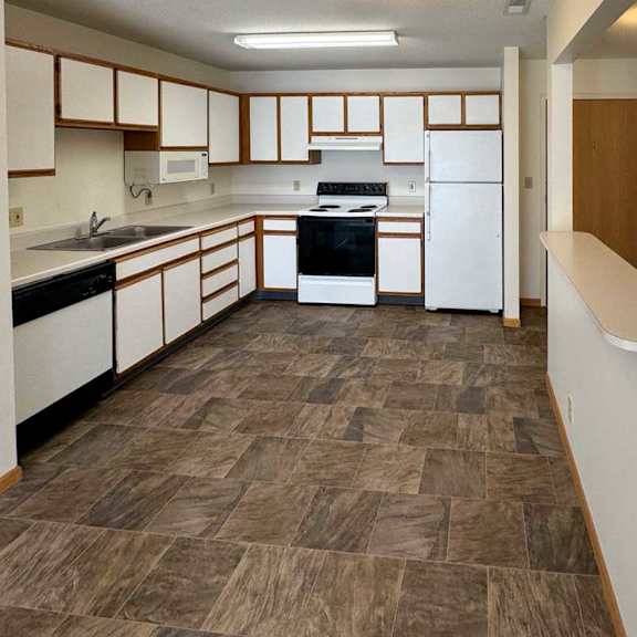 Thumbnail 8 of 28 a kitchen with white appliances and white cabinets with oak trim
