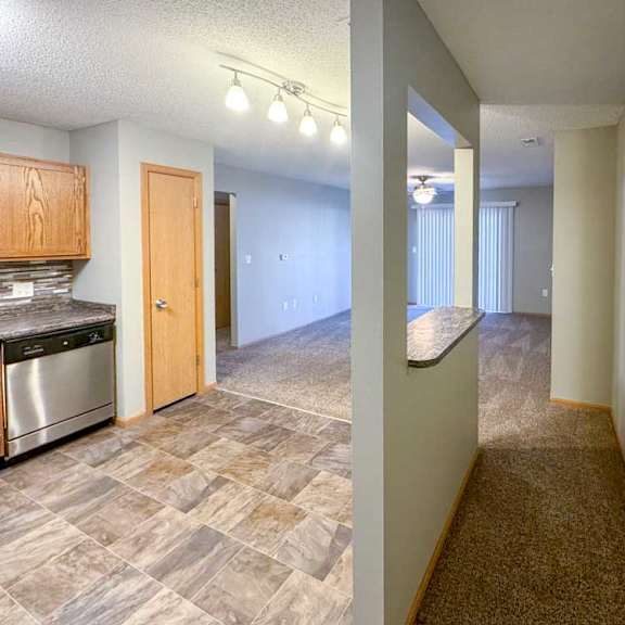 Thumbnail 2 of 9 A kitchen with a windowed divider wall, creating a hallway space for the main entry.