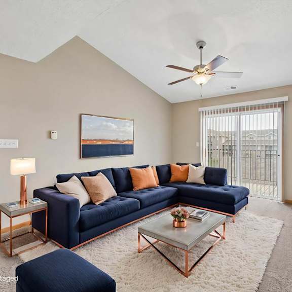 Thumbnail 2 of 20 Virtually staged living room with a sectional sofa, coffee table, ceiling fan, large window, and neutral apartment finishes.
