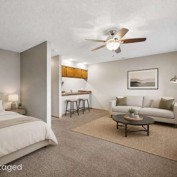 Thumbnail 2 of 29 Virtually staged studio apartment featuring a sleeping area, living space, coffee table, ceiling fan, and partial view of the kitchen.