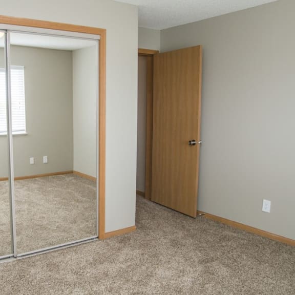 Thumbnail 7 of 11 a bedroom with a mirrored closet and a window