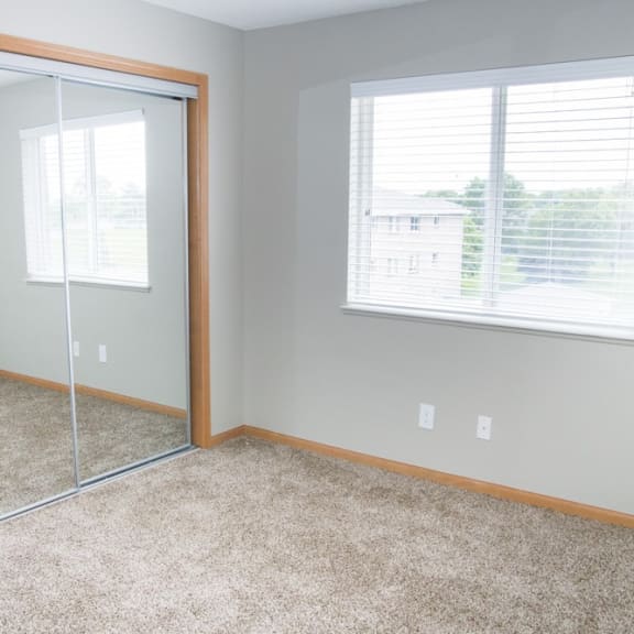 Thumbnail 9 of 11 an empty bedroom with a mirror and a window