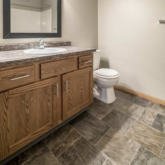 Thumbnail 14 of 14 a bathroom with a sink, mirror, and wooden cabinets