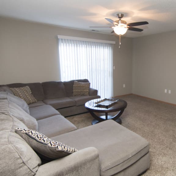 Thumbnail 4 of 10 a living room with a couch and a ceiling fan