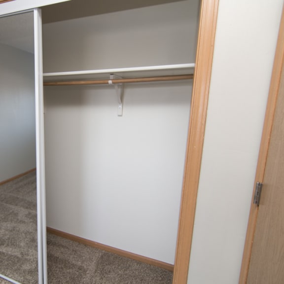 Thumbnail 7 of 10 an empty closet in a room with a mirrored door