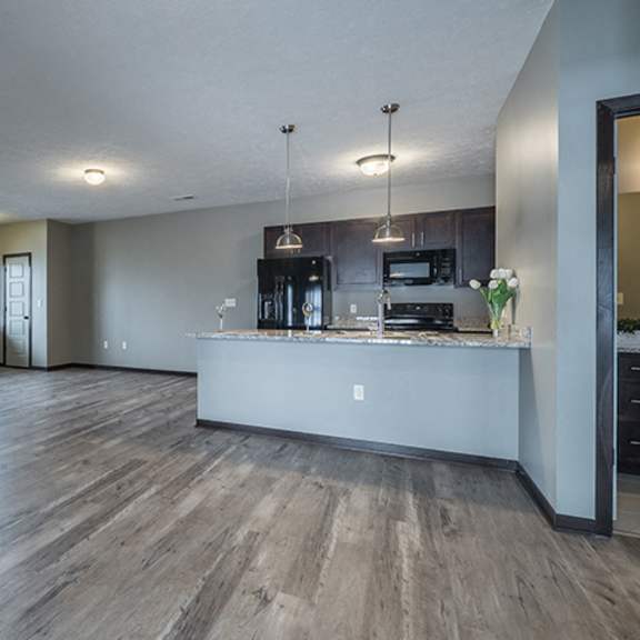 Thumbnail 4 of 12 view of open floorplan living space and kitchen including island at North Pointe Villas