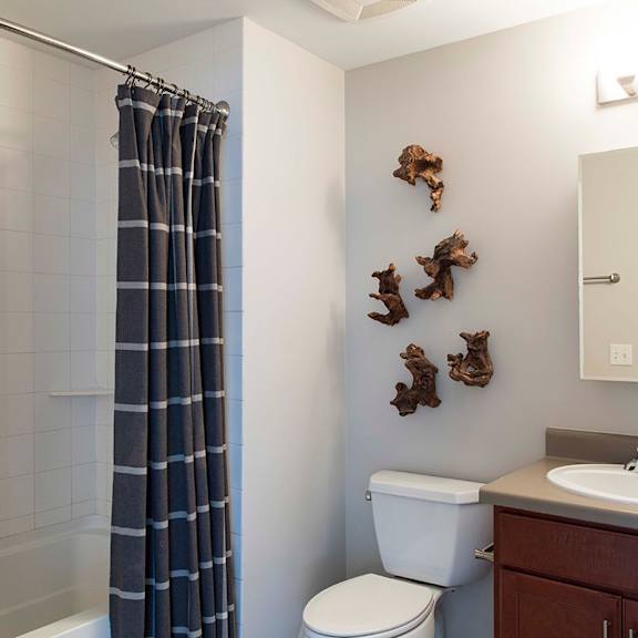 Thumbnail 8 of 8 A bathroom with a toilet, sink, and a shower with a curtain.