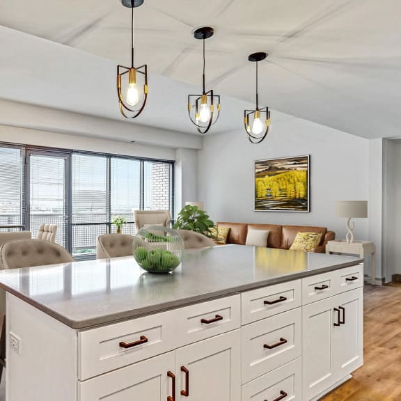 Thumbnail 6 of 22 The fantastic chef’s kitchen with seated island overlooks the spacious dining and living area 2 bedroom penthouse floor plan at Midtown Crossing Apartments Omaha.