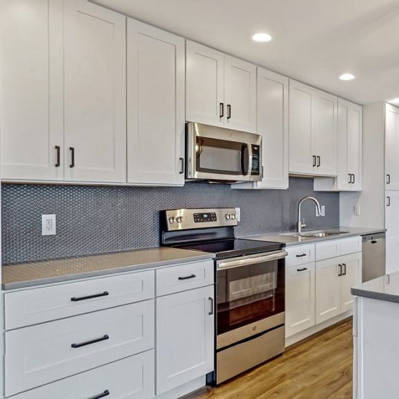 Thumbnail 4 of 22 You'll love cooking and entertaining in this kitchen with quartz counters and custom tile backsplash.