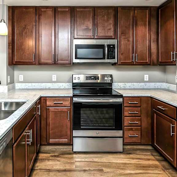 Thumbnail 5 of 9 U-shaped kitchen with stainless steel appliances and white counters
