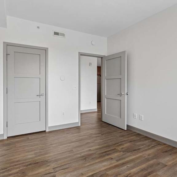 Thumbnail 35 of 35 A room with two doors and a wooden floor.