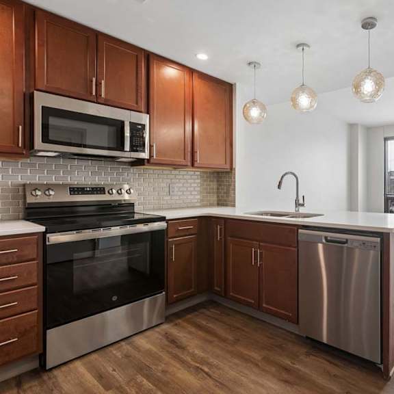 Thumbnail 24 of 35 A modern kitchen with wooden cabinets and stainless steel appliances.