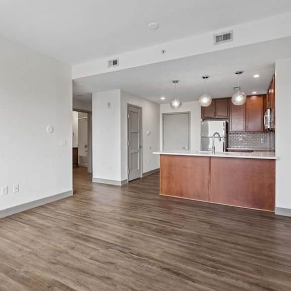 Thumbnail 29 of 35 A kitchen with white walls and wooden floors.